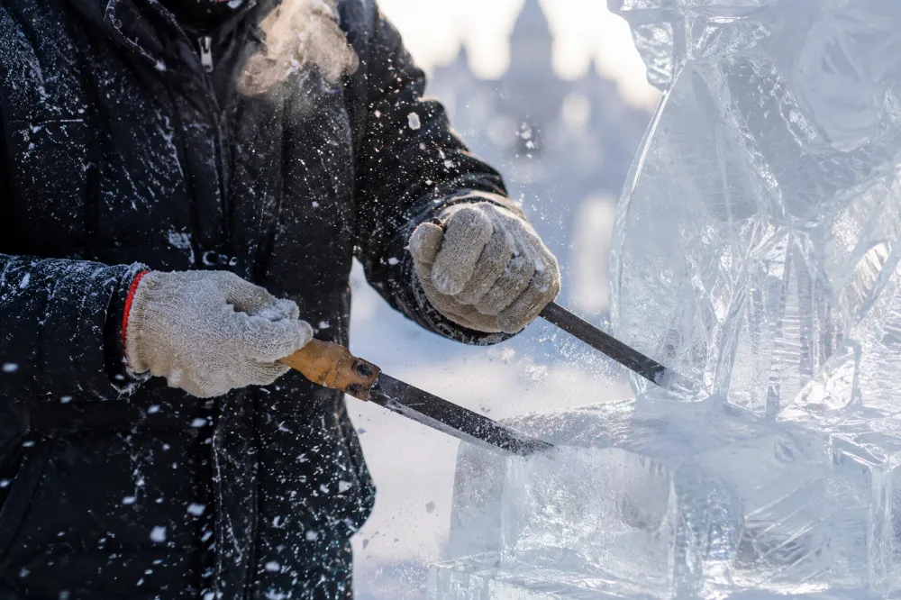 An ice sculptor carving a block of ice during preparations for the Harbin Snow Festival