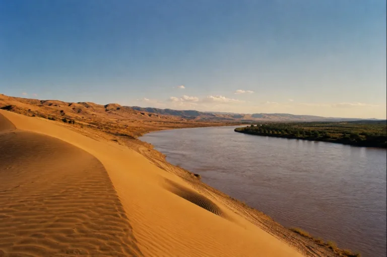 Tengger Desert dunes meeting the Yellow River at Shapotou, Ningxia, late afternoon light