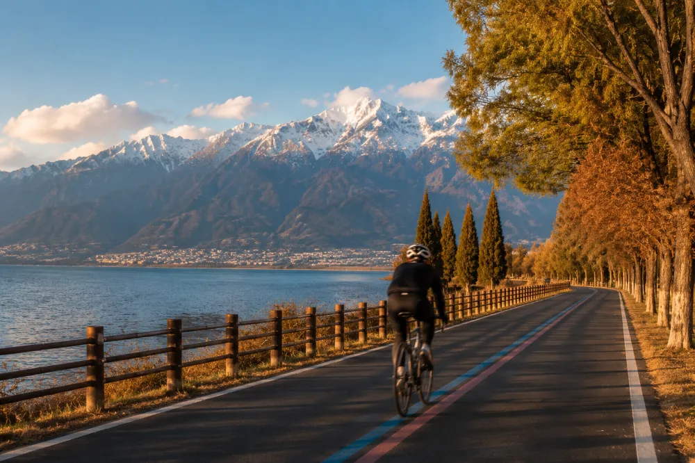 A cyclist riding the Haixi ecological corridor along Erhai Lake with Cangshan mountain in the background