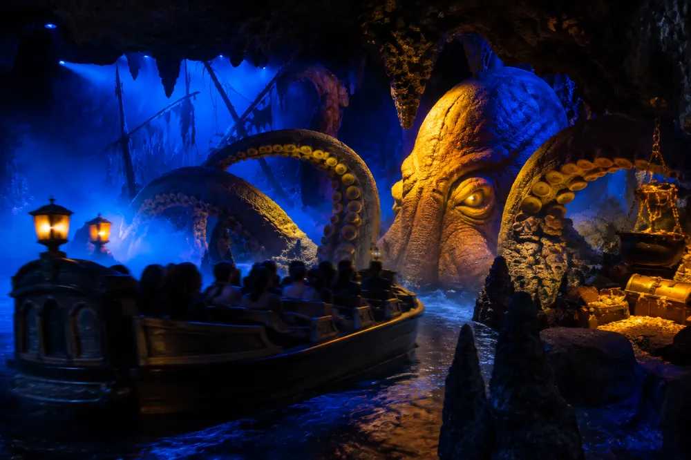 A boat passing a giant animatronic Kraken inside the Pirates of the Caribbean: Battle for the Sunken Treasure ride at Shanghai Disneyland